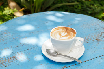 Cup of latte coffee on blue wooden table