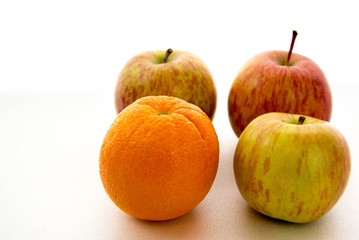 line of apples with one orange