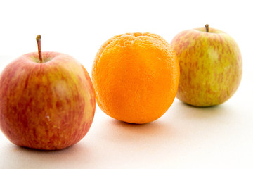 line of apples with one orange