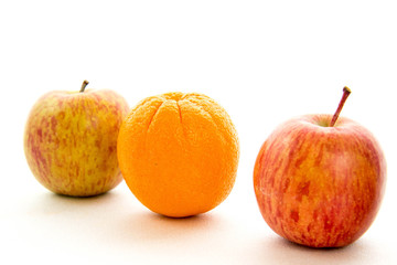 line of apples with one orange