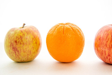 line of apples with one orange