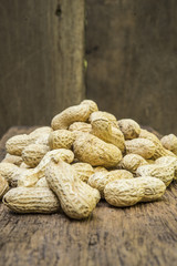 peanuts in shells on wood background
