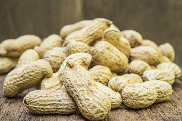 peanuts in shells on wood background