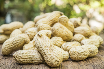 peanuts in shells on wood background