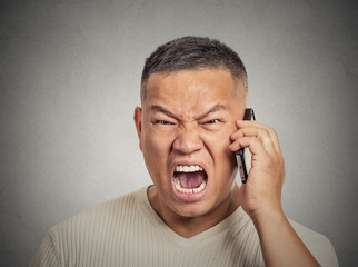 Angry middle aged man employee shouting while on phone