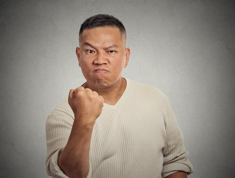 angry middle aged man showing fist isolated on grey background 