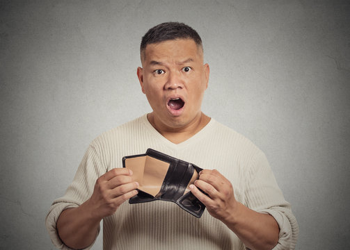 shocked puzzled business man employee holding empty wallet