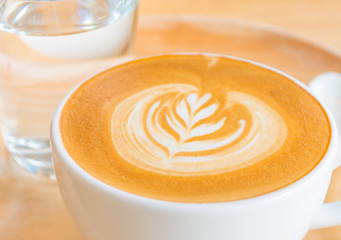 A Latte Coffee art on the wooden desk.