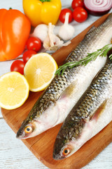 Fresh raw fish and food ingredients on table