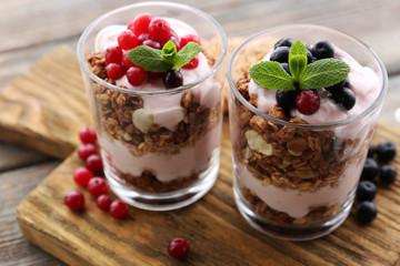 Healthy layered dessert with muesli and berries on table