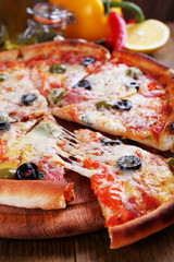 Pizza with cheese on board and wooden table background