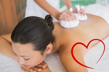 Obraz na płótnie Canvas Content brunette getting a herbal compress massage