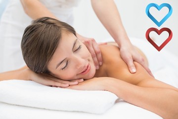 Obraz na płótnie Canvas Attractive young woman receiving shoulder massage at spa center