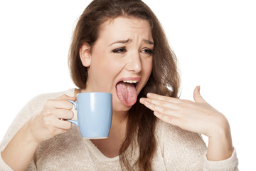 the young woman burned her tongue of hot tea
