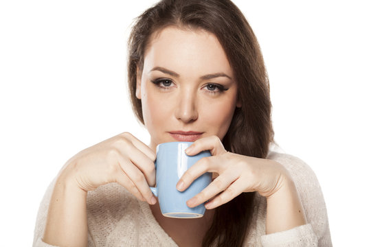 positive young woman holding a cup of tea