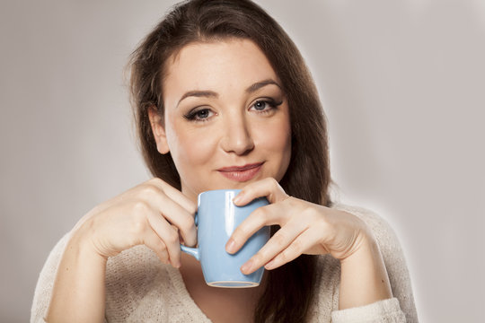 positive young woman holding a cup of tea
