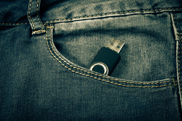 The pocket of jeans with flash card. Cloth background