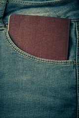 The pocket of jeans with document. Cloth background. Toned