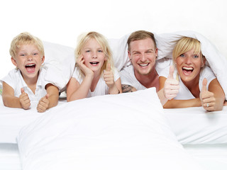 Parents have fun with kids in bed