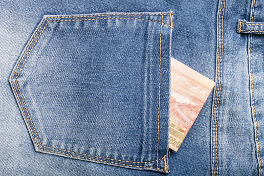 The pocket of jeans with money. Cloth background