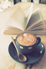 cup of coffee with book in coffee shop vintage color
