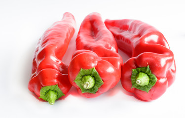 Three red peppers on white