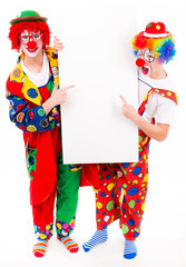 fröhliche clowns zeigen auf werbeplakat