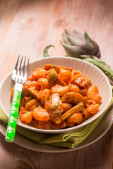 pasta with artichoke and tomatoes sauce, selective focus