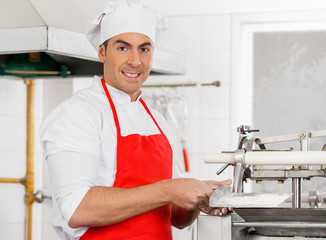 Smiling Chef Standing By Ravioli Pasta Machine