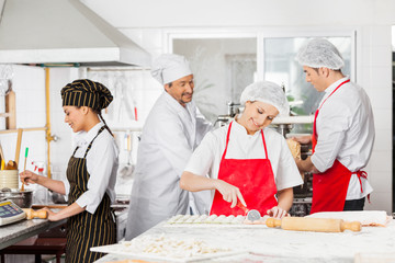 Chefs Preparing Pasta In Kitchen