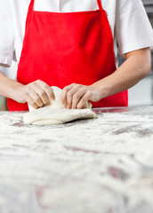 Female Chef Kneading Dough At Messy Counter