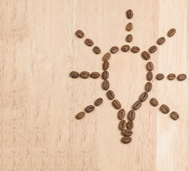 Coffee beans are laid out on board in form of a idea lamp