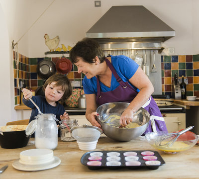 Woman with grandson baking in kitchen