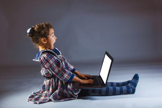 Girl Looking Computer On A Gray Background Surprise