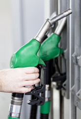 Pumping gas at gas pump. Closeup of man pumping gasoline fuel in