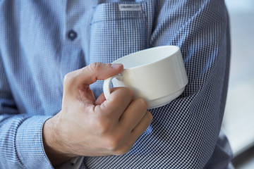 businessman with a cup of coffee at the window
