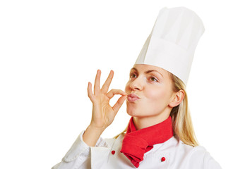 Köchin macht Zeichen für gutes Aroma mit Hand