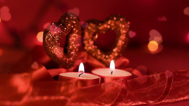 Valentines day,  two candles burning in front of two hearts