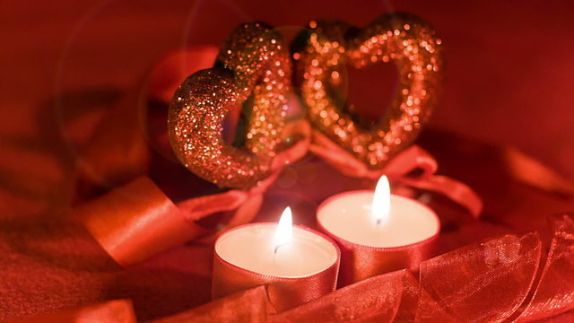 Valentines day,  two candles burning in front of hearts