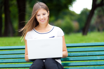 Young woman using a laptop at the park