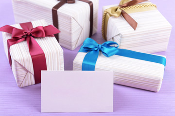 Cute presents with greeting card on light blue uneven