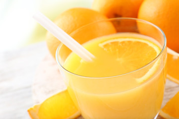 Glass of orange juice with straw and slices