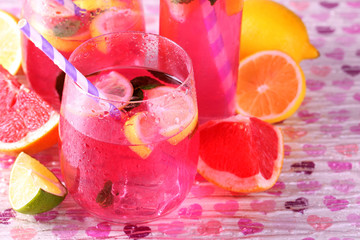 Pink lemonade in glasses and bottle on bright background