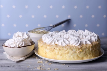 Tasty homemade meringue cake on wooden table, on blue