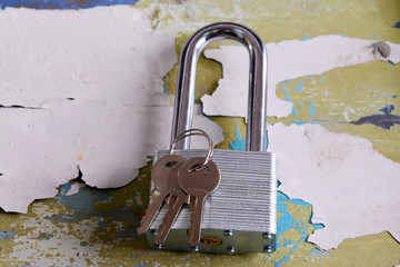 Padlock with keys on wooden background