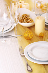 Beautiful holiday table setting in white and gold color