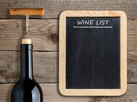 Wine list on blackboard and wine bottle on wooden background