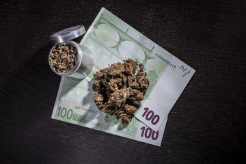 Metal grinder with marijuana and money