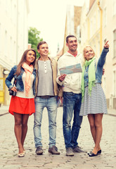 Naklejka premium group of smiling friends with map and photocamera