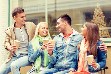 group of smiling friends with take away coffee